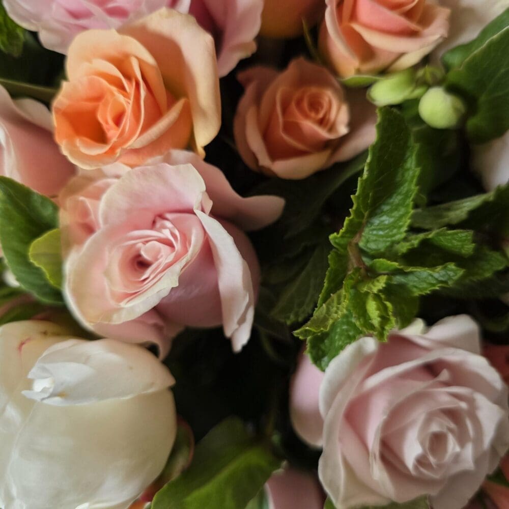 High‑resolution photograph of a rose bouquet with mint leaves and peony buds by Greg Halpern.